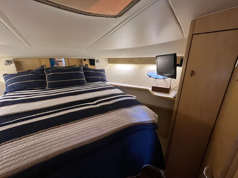 Slide: The Image of Cozy bedroom in 2001 Tiara Yachts 4100 Open with striped bedding and small TV. - 38