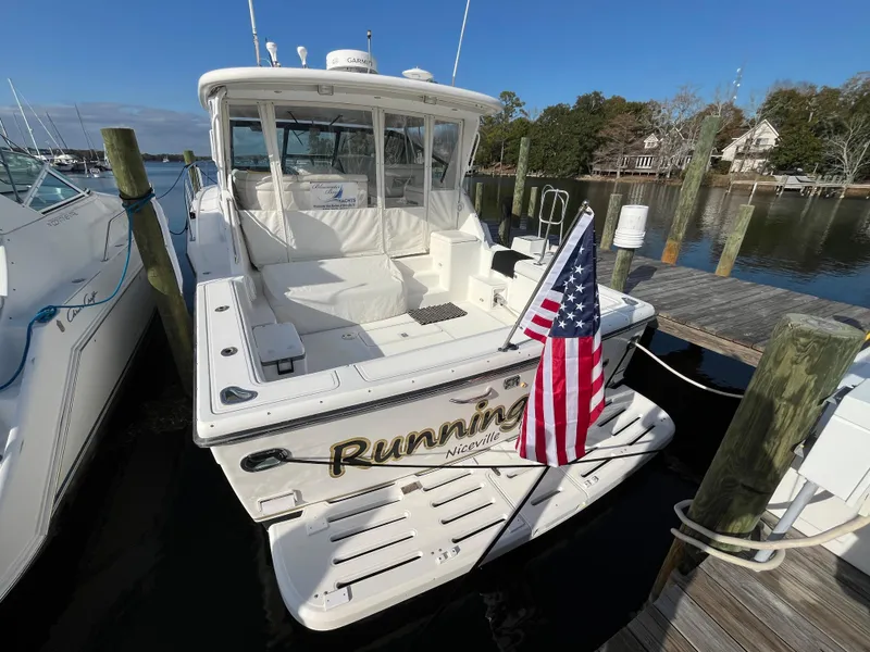 Slide: The Image of 2001 Tiara Yachts 4100 Open docked, displaying American flag, sunny day. - 44