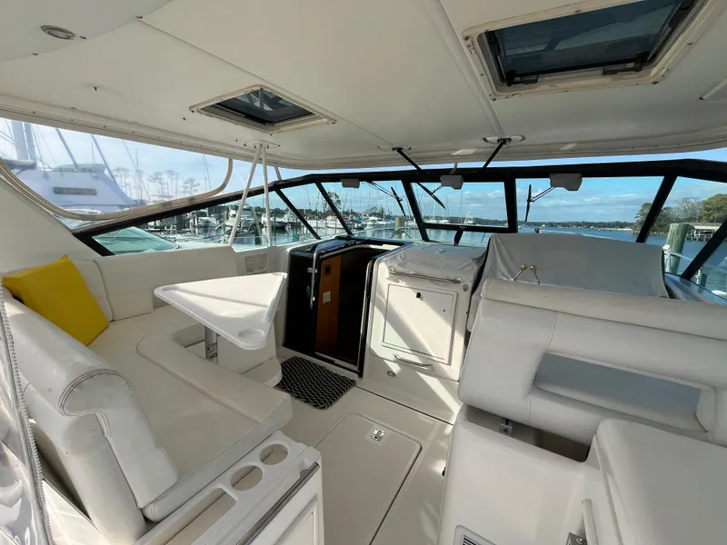 Slide: The Image of 2001 Tiara Yachts 4100 Open interior with white seating and table, docked at marina. - 8
