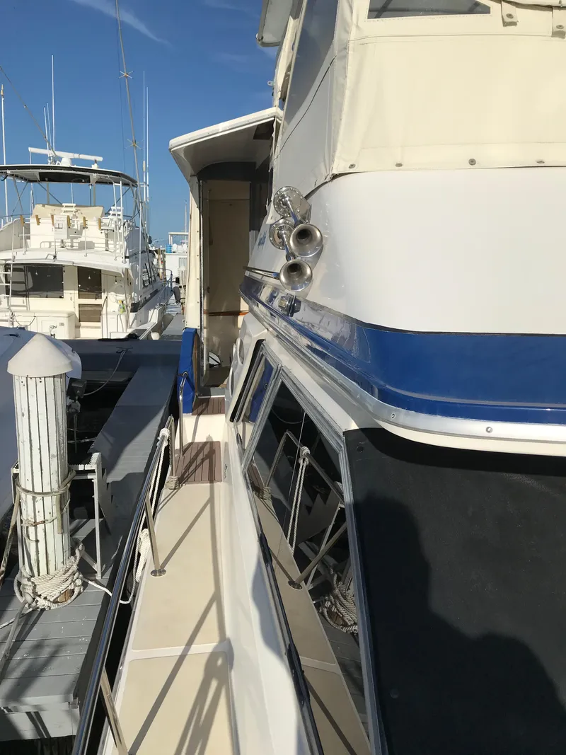 Slide: The Image of 1987 Sea Ray 410 Aft Cabin yacht docked at marina, side view. - 13