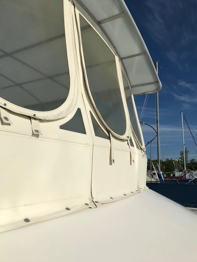 Slide: The Image of 1987 Sea Ray 410 Aft Cabin boat with white exterior and windows, docked under clear sky. - 18