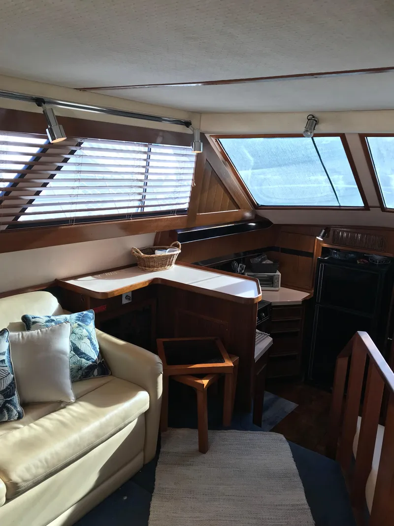 Slide: The Image of 1987 Sea Ray 410 Aft Cabin interior with cozy seating and wooden accents. - 22