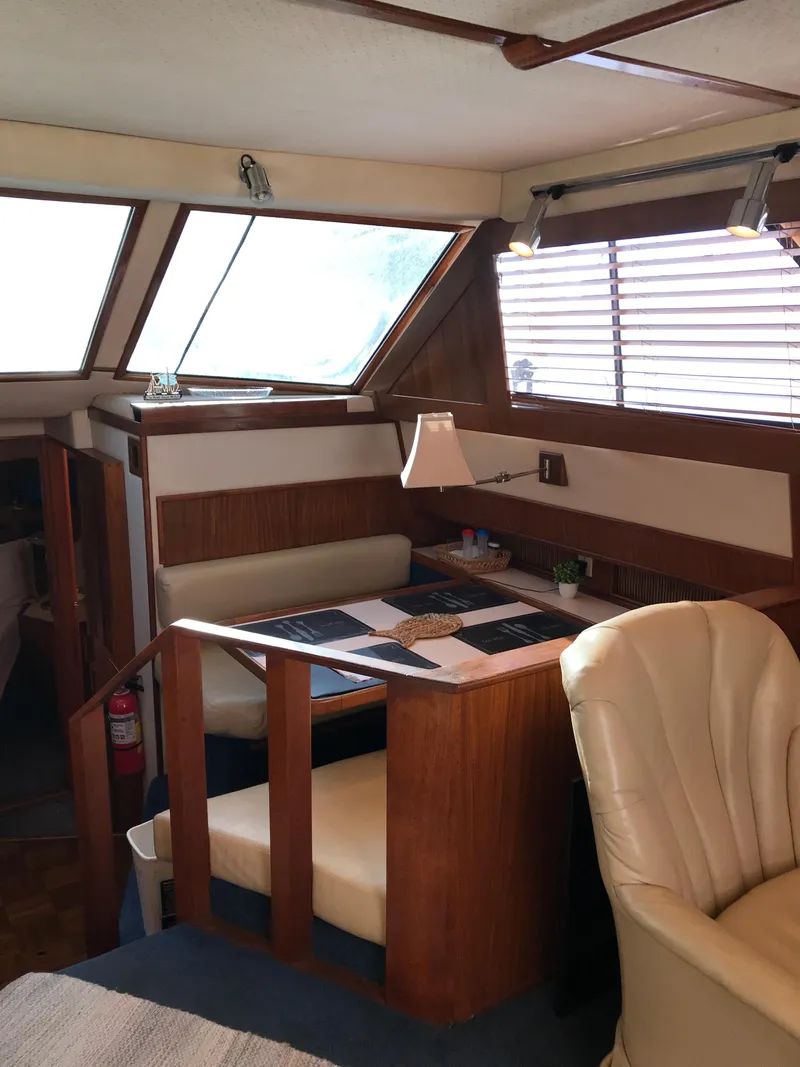 Slide: The Image of 1987 Sea Ray 410 Aft Cabin interior with dining area and seating. - 24