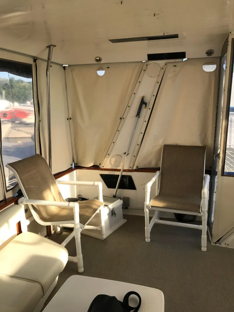 Slide: The Image of 1987 Sea Ray 410 Aft Cabin interior with seating area and natural light. - 25