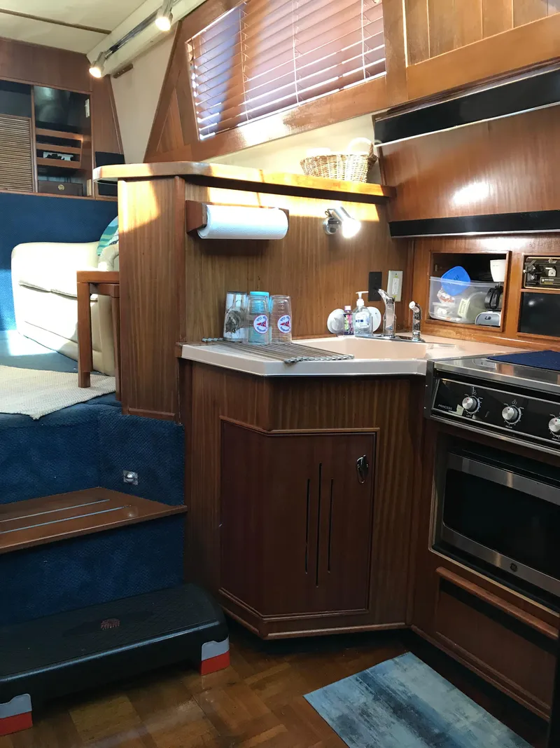 Slide: The Image of 1987 Sea Ray 410 Aft Cabin interior kitchen with wood cabinetry and modern appliances. - 28