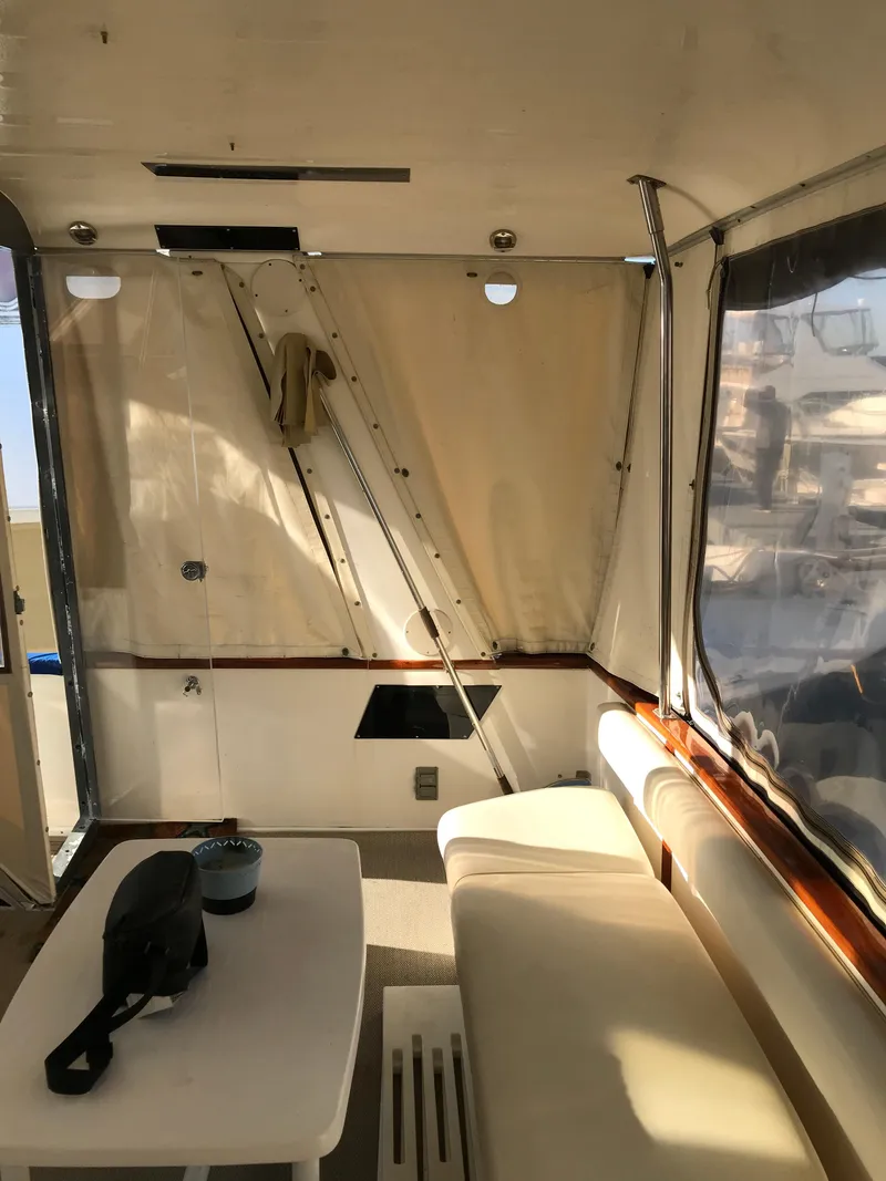 Slide: The Image of 1987 Sea Ray 410 Aft Cabin interior with seating and table, featuring beige upholstery. - 31