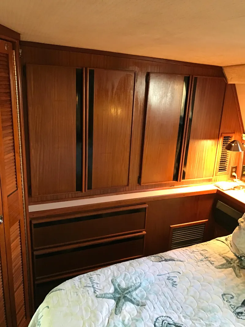 Slide: The Image of 1987 Sea Ray 410 Aft Cabin interior with wooden cabinetry and cozy bedding. - 33