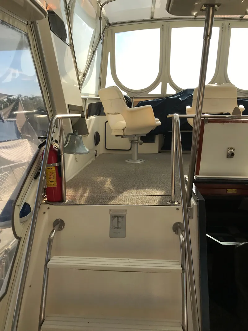 Slide: The Image of 1987 Sea Ray 410 Aft Cabin interior with helm chair and stairs. - 34