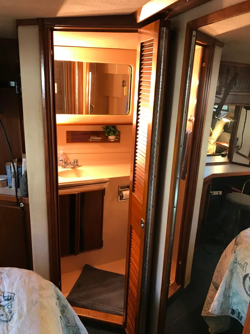 Slide: The Image of 1987 Sea Ray 410 Aft Cabin interior with wooden cabinetry and compact bathroom. - 35