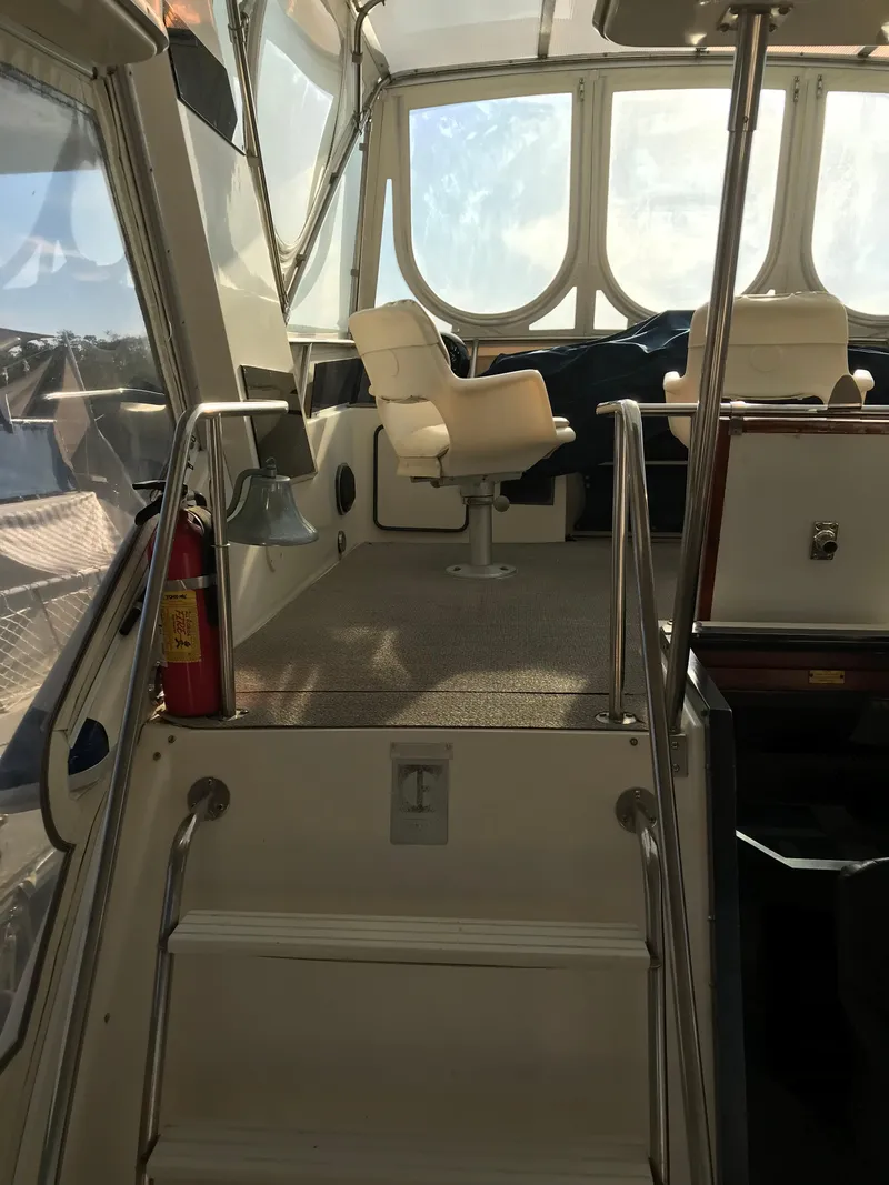 Slide: The Image of 1987 Sea Ray 410 Aft Cabin interior with helm chair and stairs. - 36
