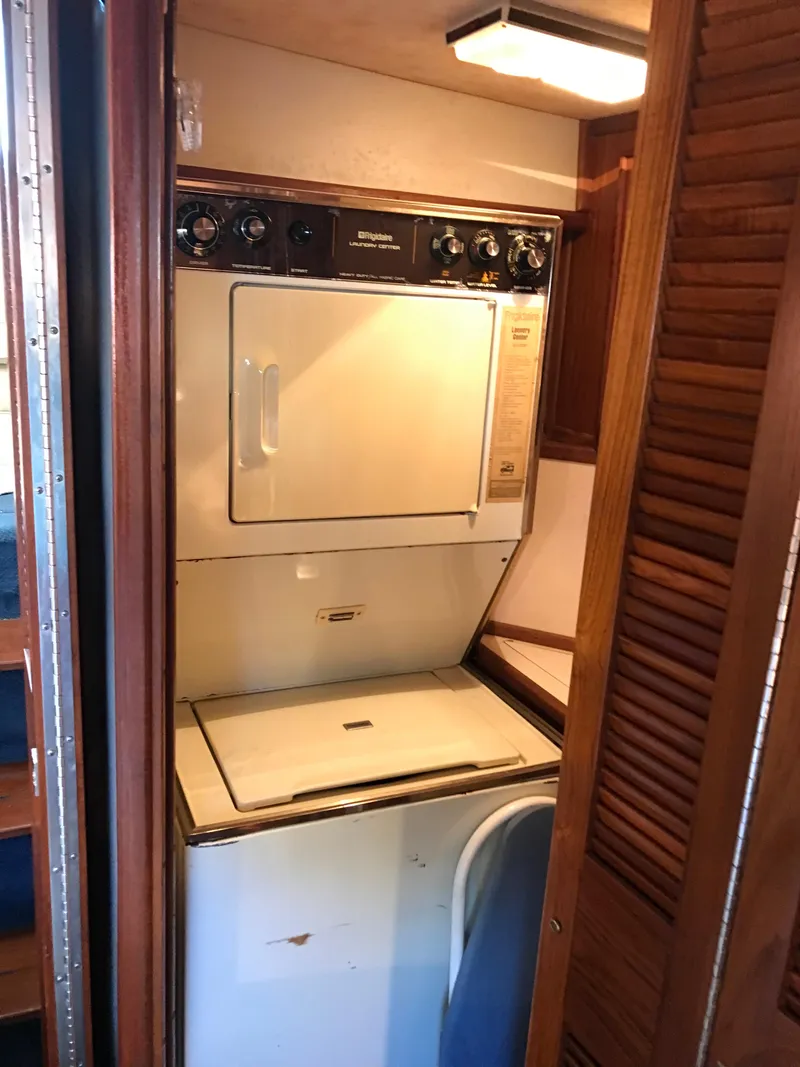 Slide: The Image of 1987 Sea Ray 410 Aft Cabin laundry area with washer and dryer. - 37