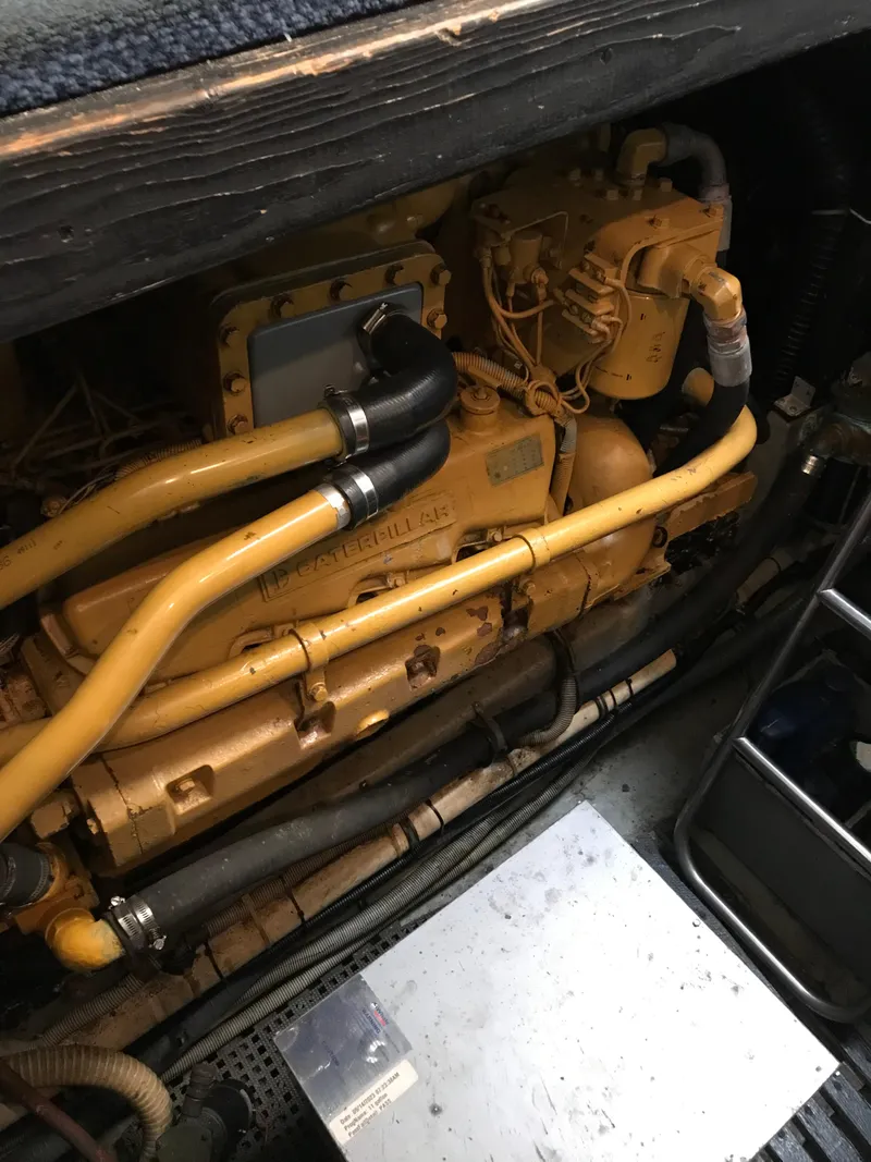Slide: The Image of Engine compartment of 1987 Sea Ray 410 Aft Cabin boat, showcasing yellow engine components. - 39