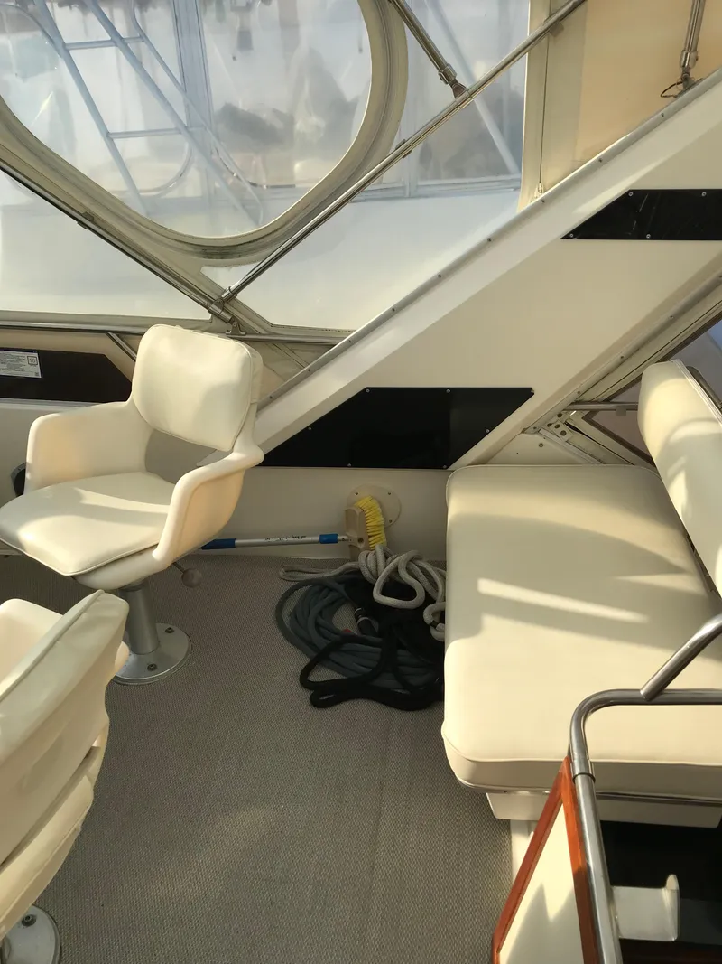 Slide: The Image of 1987 Sea Ray 410 Aft Cabin interior with white seating and nautical equipment. - 40