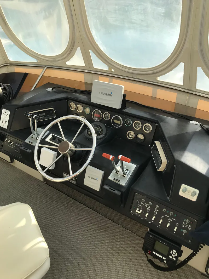 Slide: The Image of 1987 Sea Ray 410 Aft Cabin helm with steering wheel, gauges, and navigation equipment. - 43