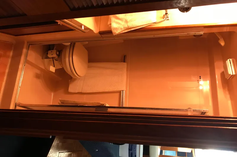 Slide: The Image of 1987 Sea Ray 410 Aft Cabin bathroom interior with toilet and towel. - 44