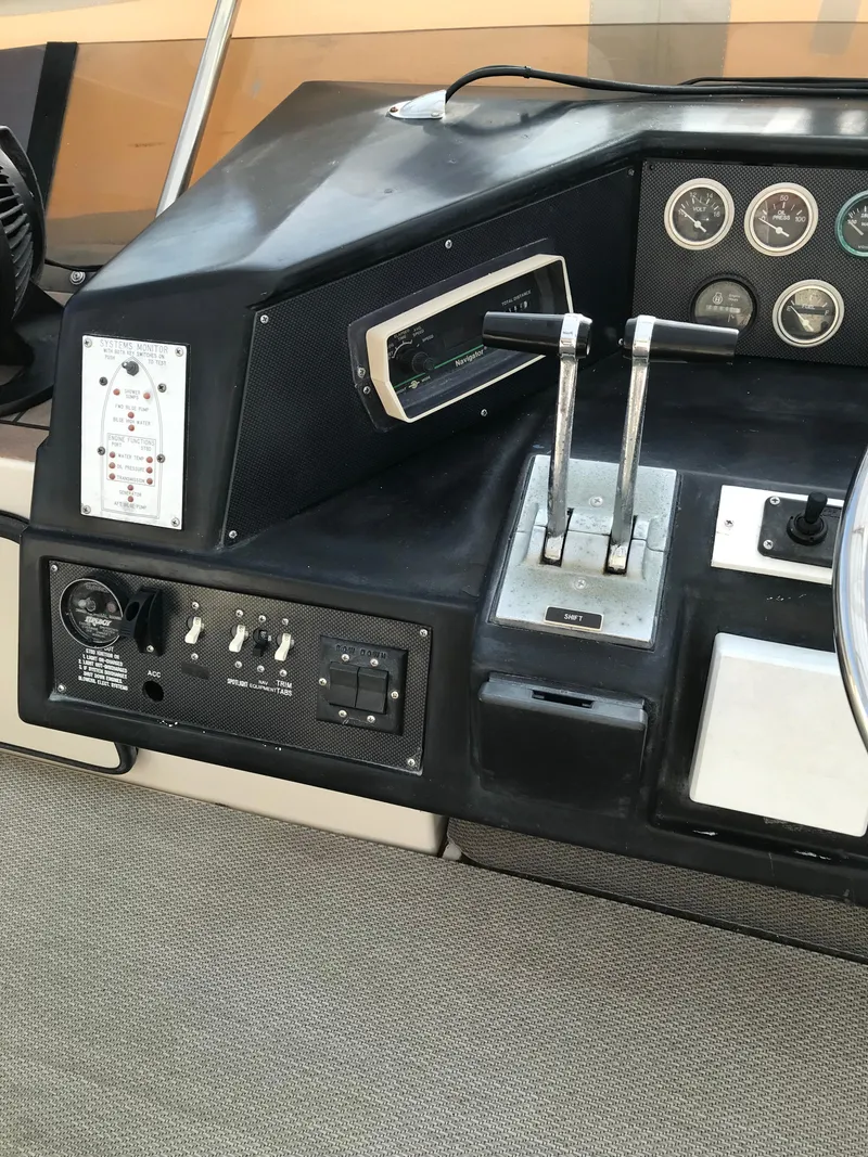 Slide: The Image of 1987 Sea Ray 410 Aft Cabin control panel with gauges and throttle levers. - 48