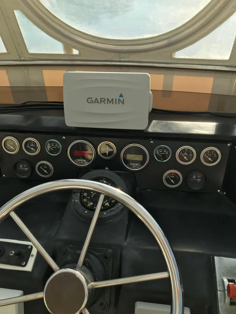 Slide: The Image of 1987 Sea Ray 410 Aft Cabin helm with Garmin navigation system and classic gauges. - 49