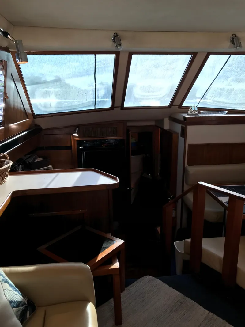 Slide: The Image of Interior of 1987 Sea Ray 410 Aft Cabin yacht with wood accents and seating area. - 55