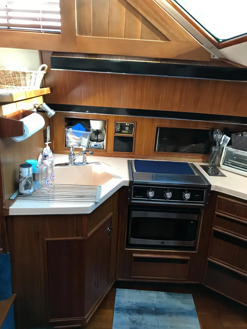 Slide: The Image of 1987 Sea Ray 410 Aft Cabin kitchen with wood cabinetry and modern appliances. - 59