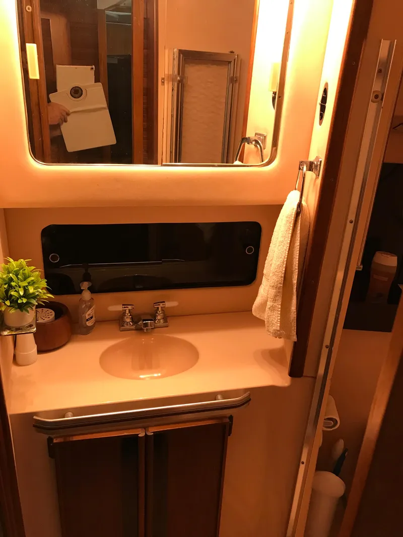 Slide: The Image of 1987 Sea Ray 410 Aft Cabin bathroom with sink, mirror, and towel. - 69
