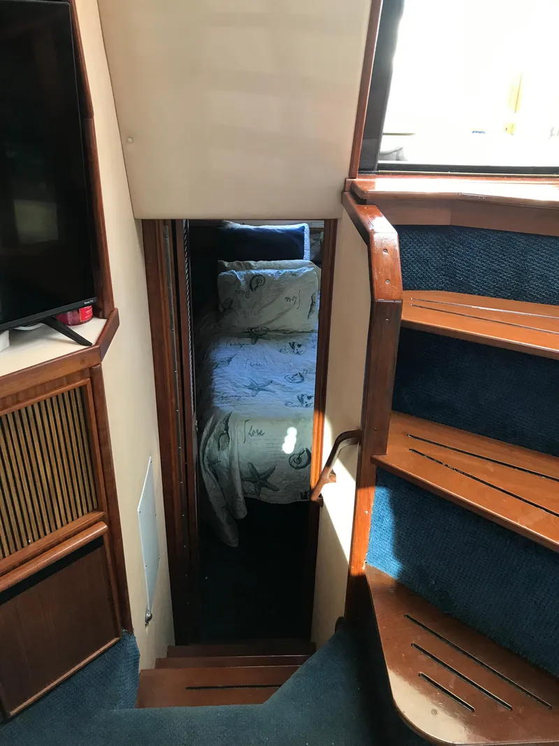 Slide: The Image of 1987 Sea Ray 410 Aft Cabin interior with stairs and cozy bedroom view. - 70