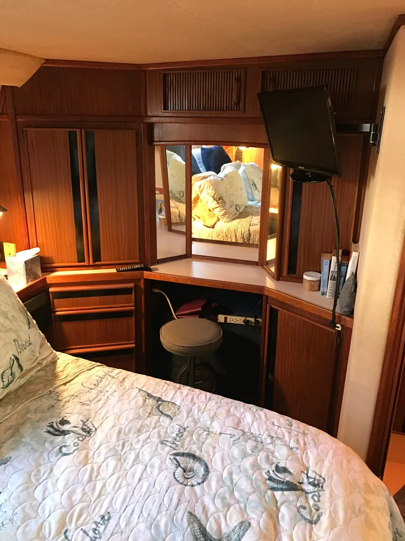 Slide: The Image of 1987 Sea Ray 410 Aft Cabin interior with wood paneling and cozy bedroom setup. - 76