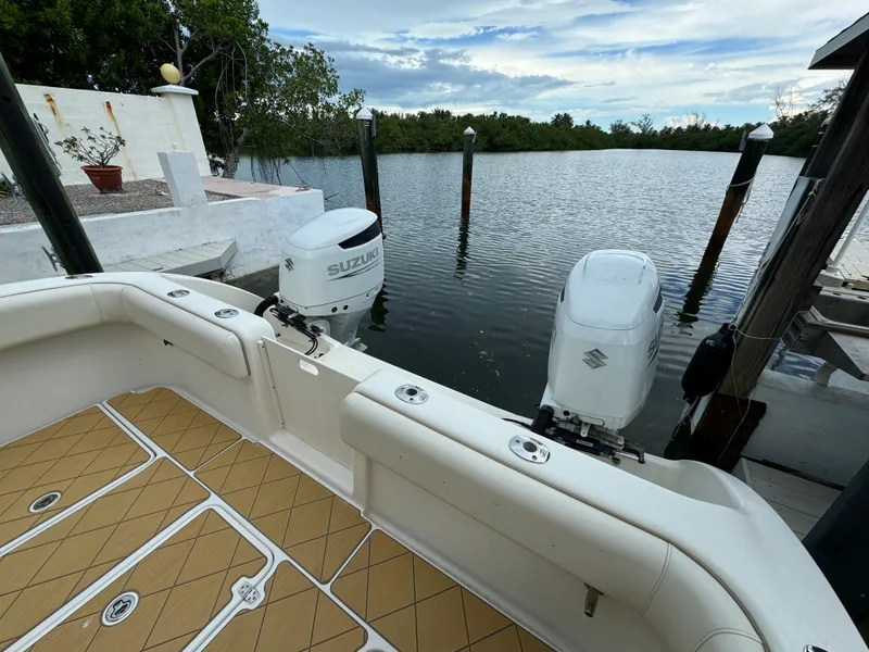 Slide: The Image of Boat docked by serene water, featuring Mamba 350 model, 2009, with Suzuki engines. - 13