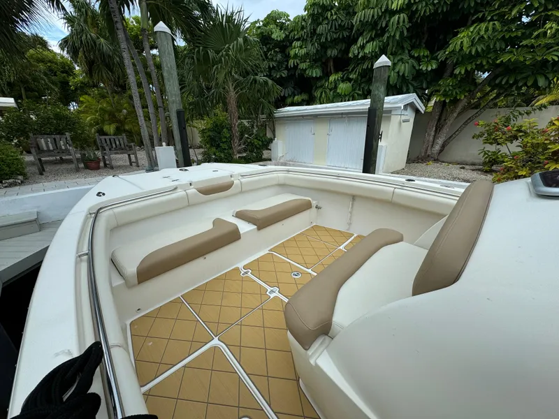 Slide: The Image of 2009 Mamba 350 boat interior with beige seating and tan flooring, surrounded by lush greenery. - 4
