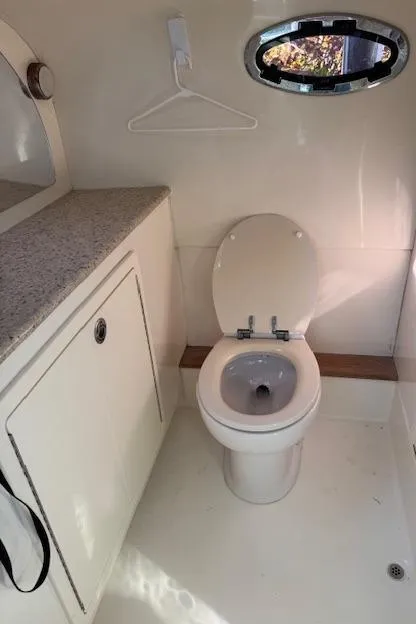 Slide: The Image of Compact bathroom in 2009 Mamba 350 boat with toilet, countertop, and porthole window. - 8
