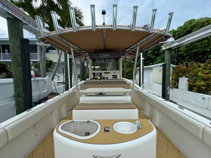 Slide: The Image of 2009 Mamba 350 boat interior with seating and helm, docked near lush greenery. - 9