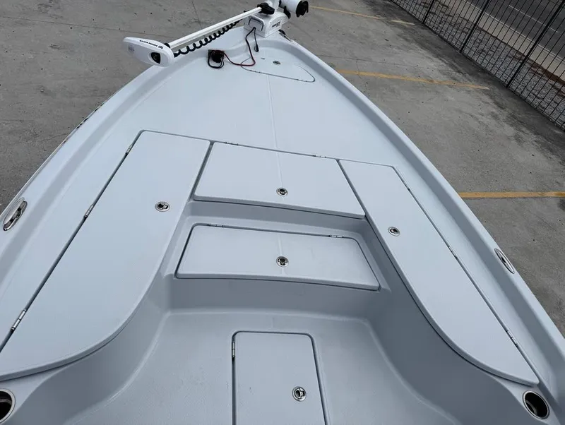 Slide: The Image of 2024 Blue Wave 2400 PureBay boat deck with storage compartments and trolling motor. - 13