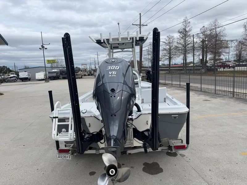 Slide: The Image of 2024 Blue Wave 2400 PureBay boat with 300 V6 engine, parked outdoors. - 6