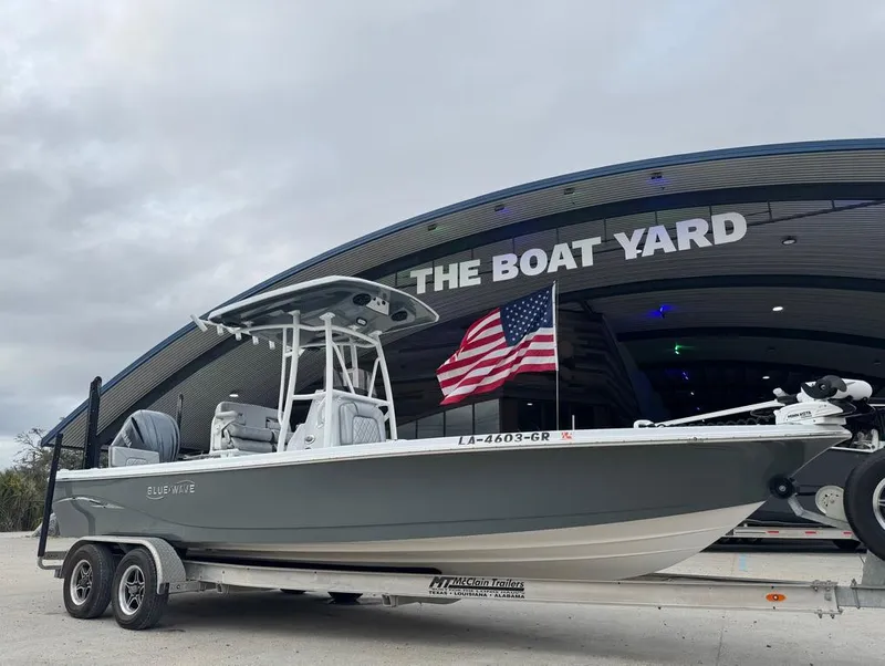 Slide: The Image of 2024 Blue Wave 2400 PureBay boat on trailer at The Boat Yard with American flag. - 8