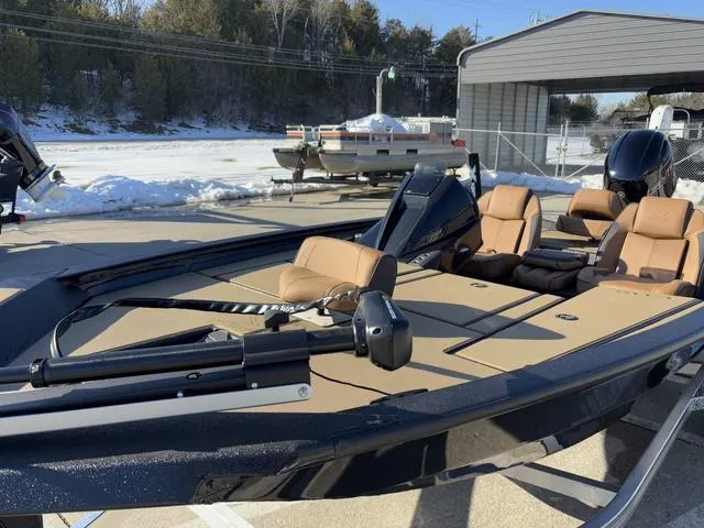 Slide: The Image of 2025 Xpress H18 boat with tan seats, parked outdoors in a snowy setting. - 10