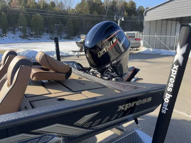 Slide: The Image of 2025 Xpress H18 boat with Yamaha engine, parked outdoors on a sunny day. - 12