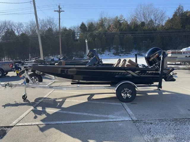 Slide: The Image of 2025 Xpress H18 boat on trailer, parked outdoors in a sunny setting. - 13