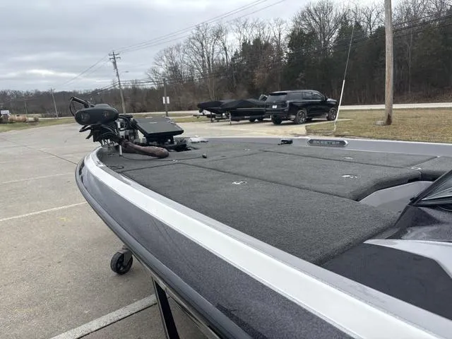 Slide: The Image of 2020 Skeeter FXR20 Limited boat parked on concrete, with trees and vehicles in the background. - 16