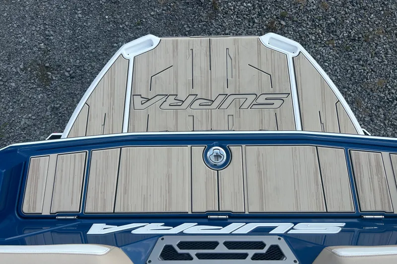 Slide: The Image of 2025 Supra SV boat deck with wood finish and logo, viewed from above. - 11