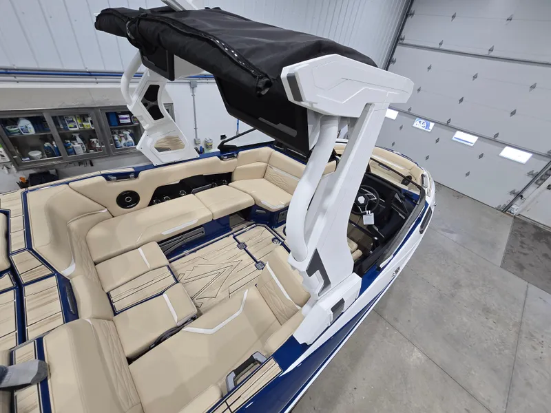 Slide: The Image of 2025 Supra SV boat with beige seating and black canopy in a garage setting. - 17