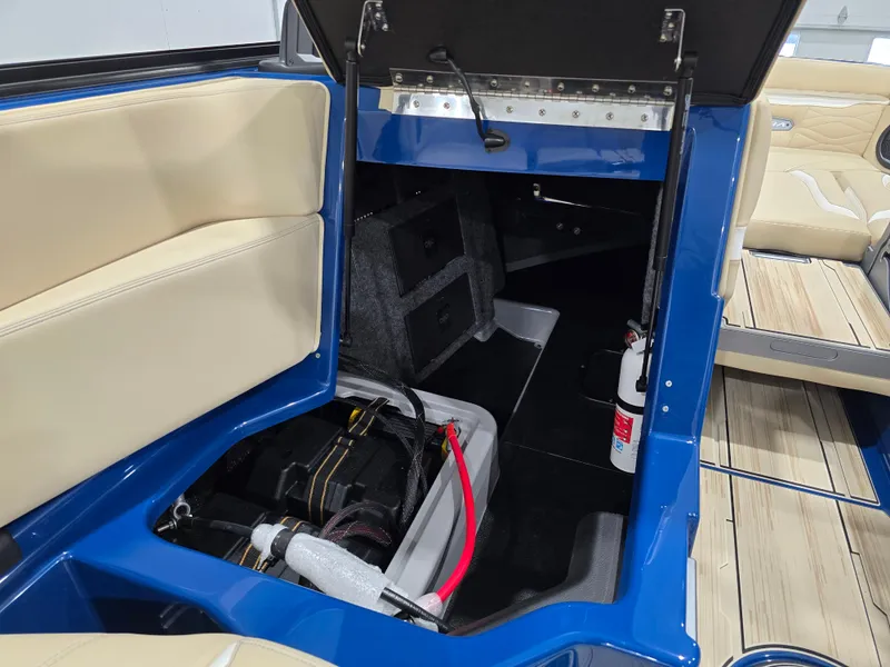 Slide: The Image of 2025 Supra SV boat interior storage compartment with battery and fire extinguisher. - 47