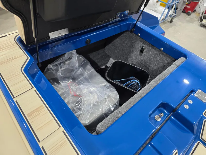 Slide: The Image of Open storage compartment of 2025 Supra SV boat, featuring blue interior and organized space. - 48