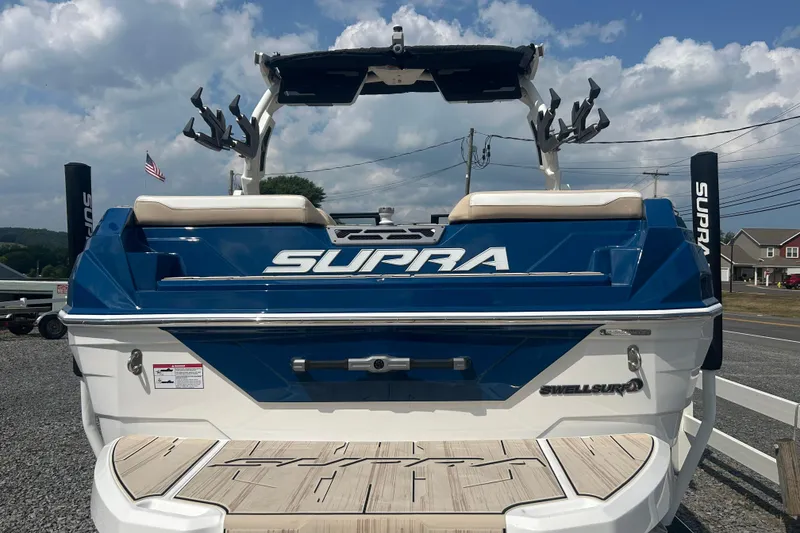 Slide: The Image of 2025 Supra SV boat, blue and white, rear view with deck and branding. - 8