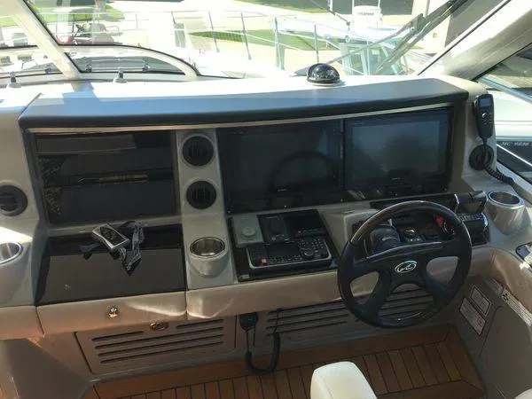 Slide: The Image of Control panel of 2010 Sea Ray 610 Sundancer yacht with steering wheel and navigation screens. - 14