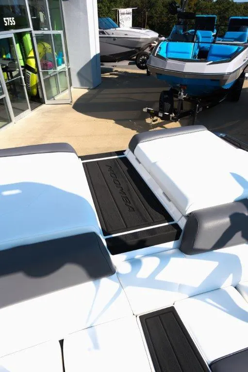 Slide: The Image of 2025 Moomba Max boat with sleek seating and modern design at a dealership. - 22
