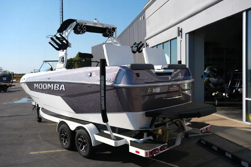 Slide: The Image of 2025 Moomba Max boat on trailer outside a building, rear view. - 3