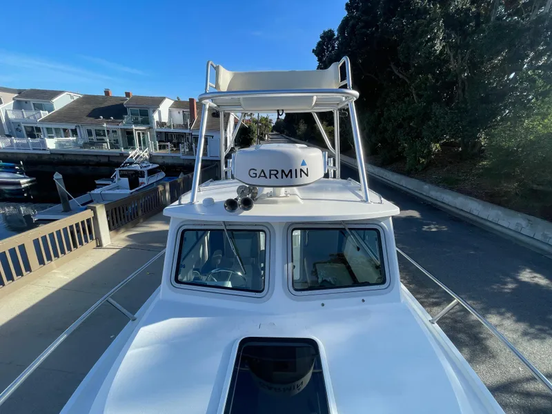 Slide: The Image of 2020 Parker 2320 Sport Cabin boat with Garmin radar, docked near waterfront homes. - 15
