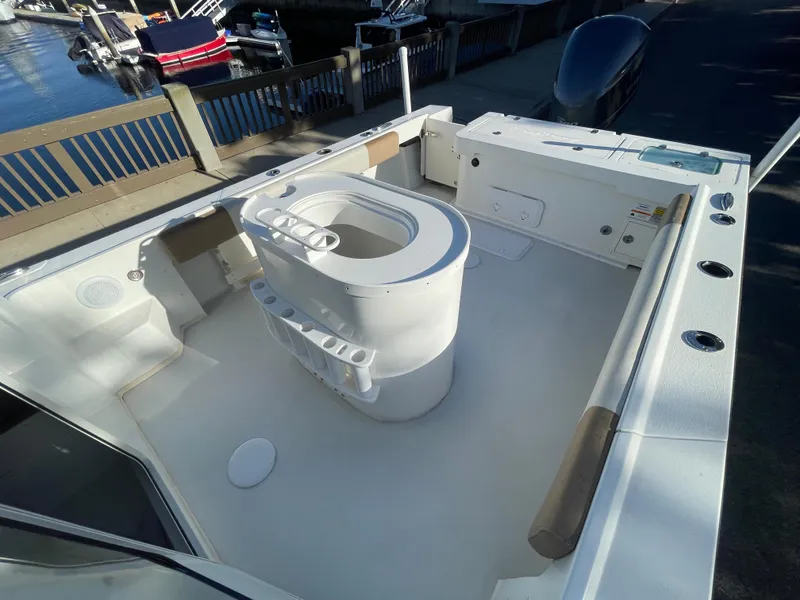 Slide: The Image of 2020 Parker 2320 Sport Cabin boat deck with seating and storage, docked by the water. - 18