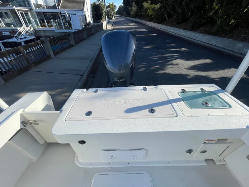 Slide: The Image of 2020 Parker 2320 Sport Cabin boat with outboard motor, docked on a sunny day. - 20