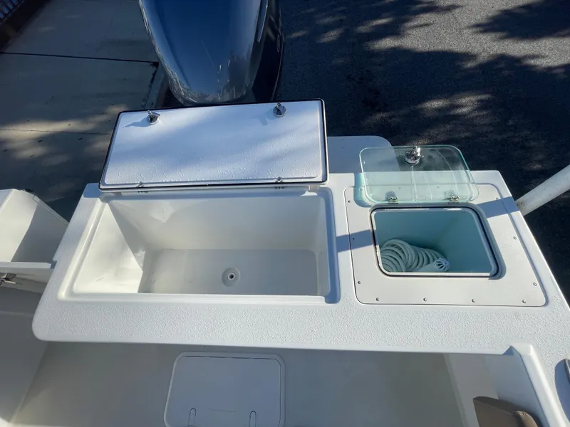 Slide: The Image of Parker 2320 Sport Cabin 2020 boat deck with storage compartments and hose. - 22