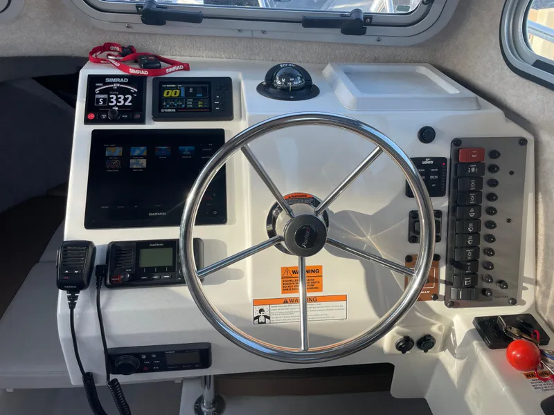 Slide: The Image of Helm of 2020 Parker 2320 Sport Cabin with navigation instruments and steering wheel. - 24